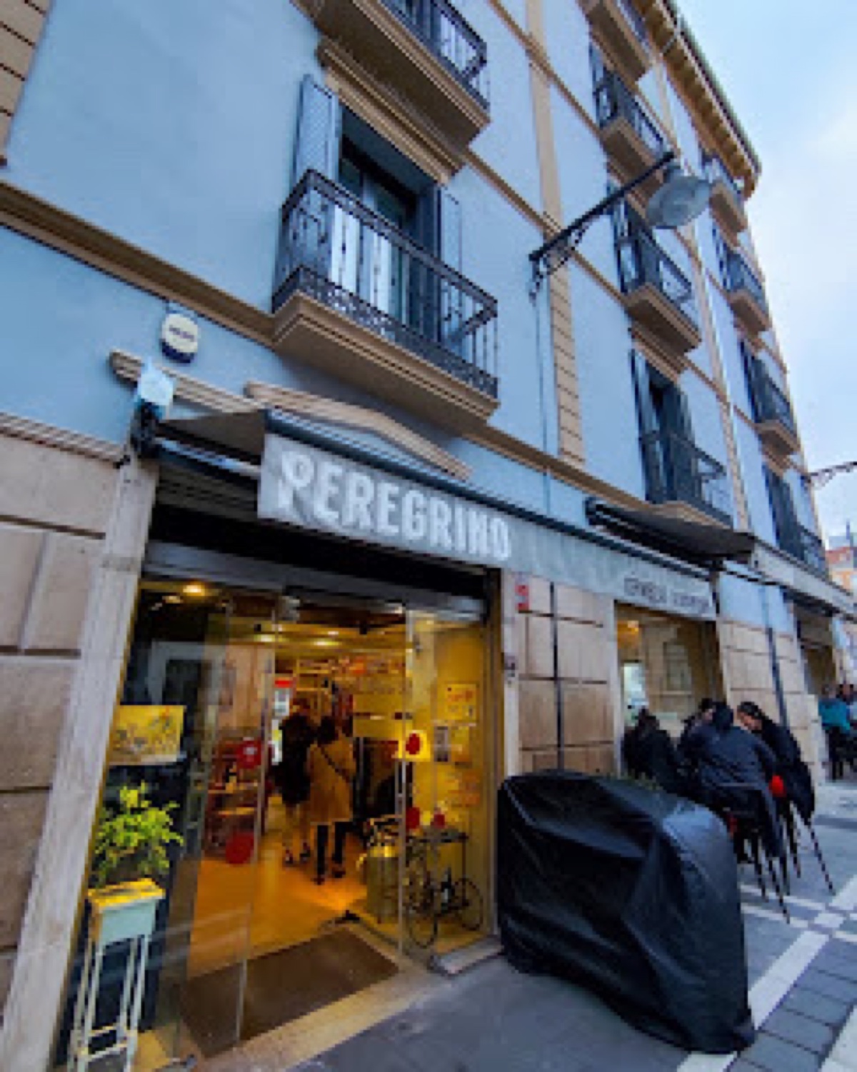 Fachada acristalada de Café Peregrino con luz cálida